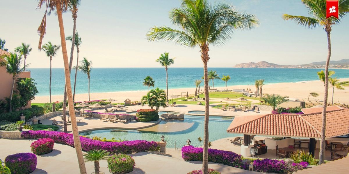Beachfront resort pool with palm trees and bougainvillea – airport transfer to Grand Velas