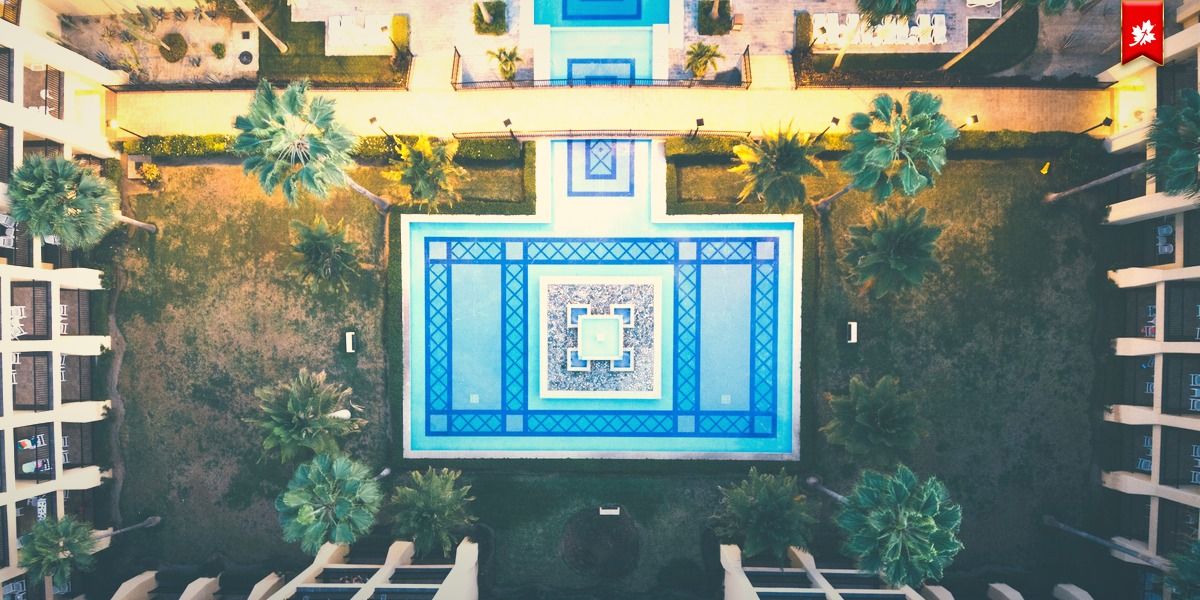 Aerial view of a resort courtyard with a blue-tiled pool – airport transfer to Hacienda del Mar