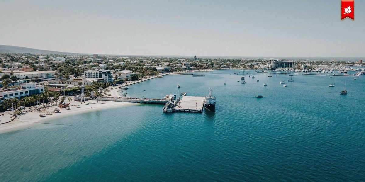 Aerial view of a coastal town with a pier and turquoise water – airport transfer to Hyatt Place La Paz
