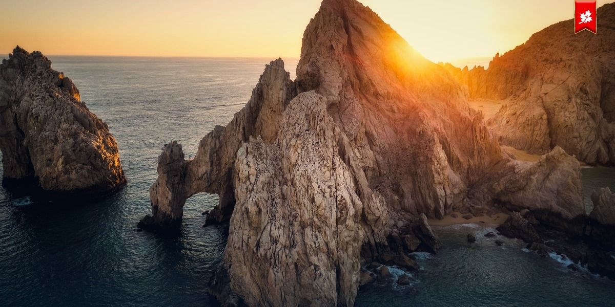 Sunset behind the rock formations of Land's End – airport transfer to ME Cabo