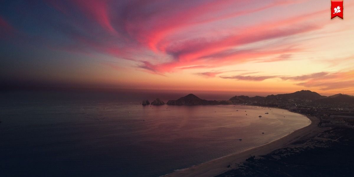 Pink sunset sky over a Cabo bay and Land's End – airport transfer to One&Only Palmilla