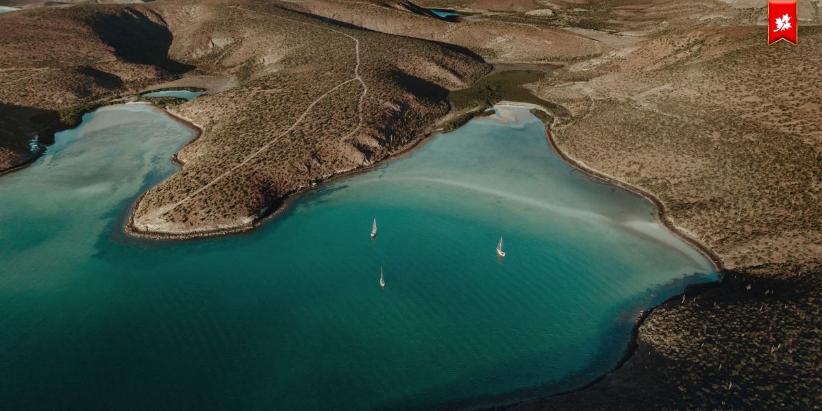 Turquoise bay surrounded by dry hills, seen from above – airport transfer to Hotel Perla