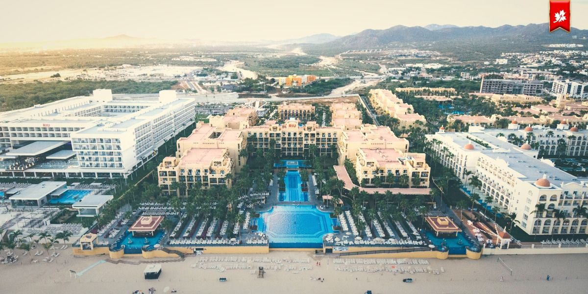 Aerial view of a large beachfront resort with several pools – airport transfer to Riu Santa Fe