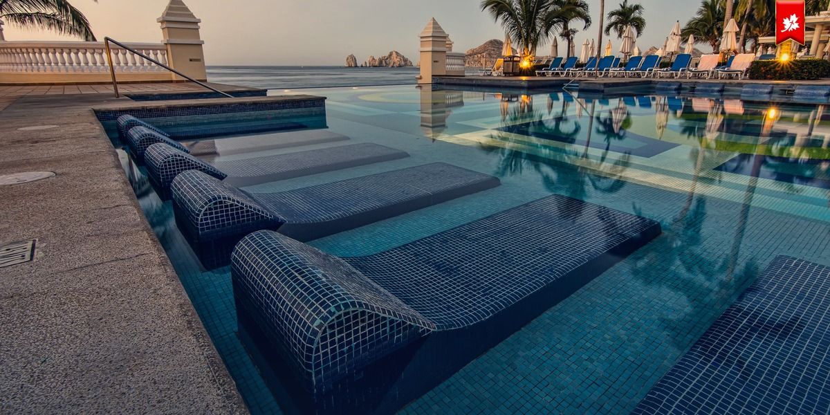 Infinity pool with tiled loungers overlooking the sea – airport transfer to Secrets Puerto