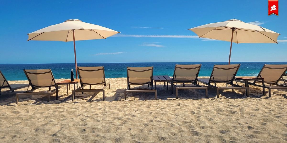 Beach loungers and umbrellas on golden sand by the sea – airport transfer to Villa del Palmar